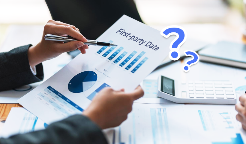 A person holding a pen in one hand and a document in the other that shows infographics on first-part data statistics 